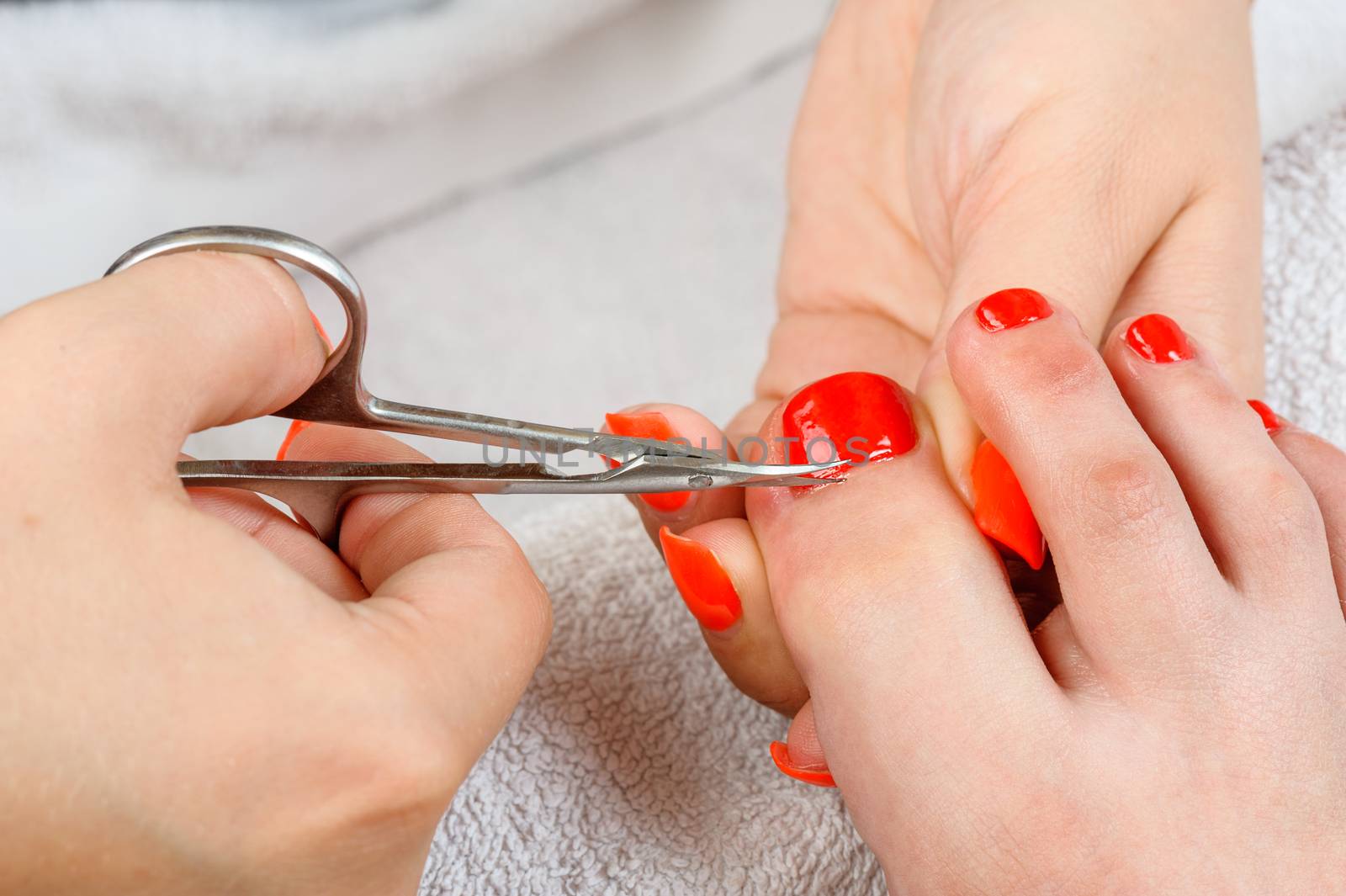 cutting cuticlle on toe with scissors, pedicure process closeup