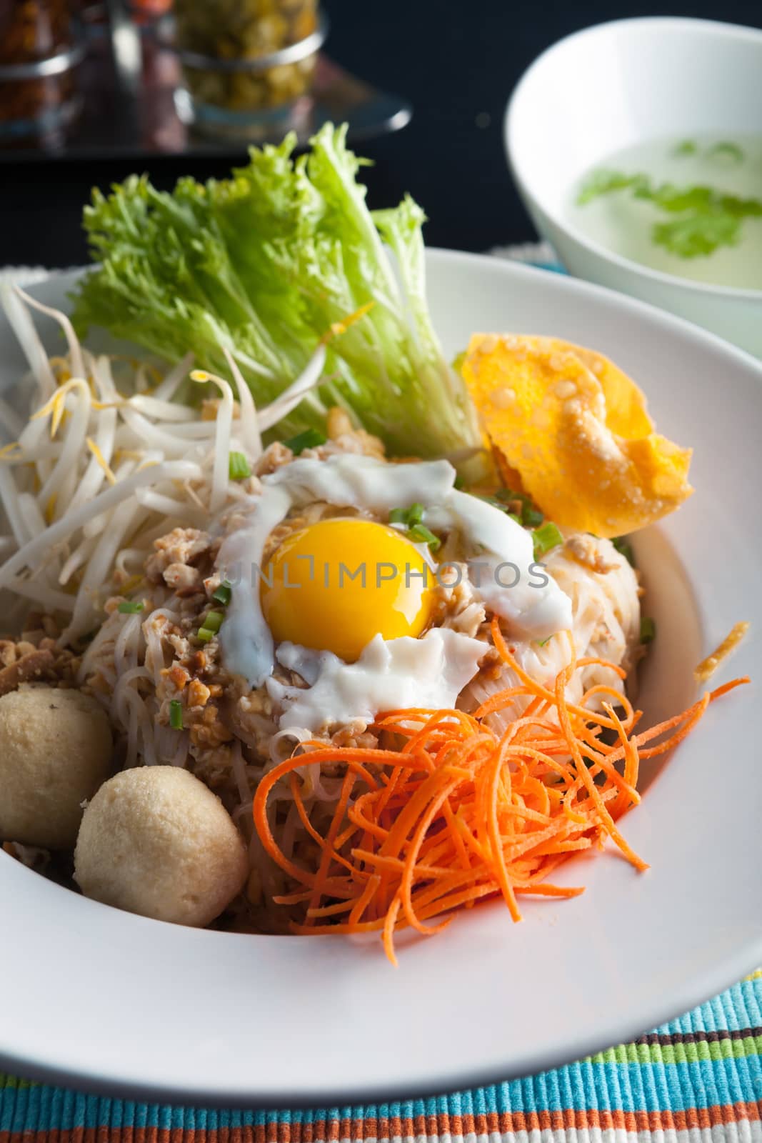 Gai pad bai gaprow style Thai dish with fried egg and rice noodles.