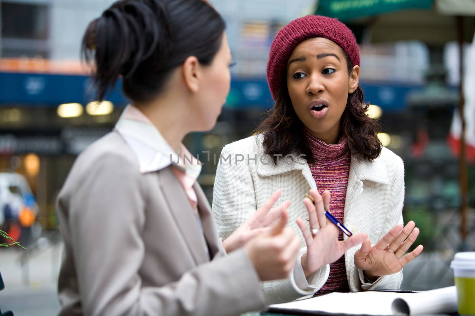 Two business women having a casual meeting or discussion in the city. 
