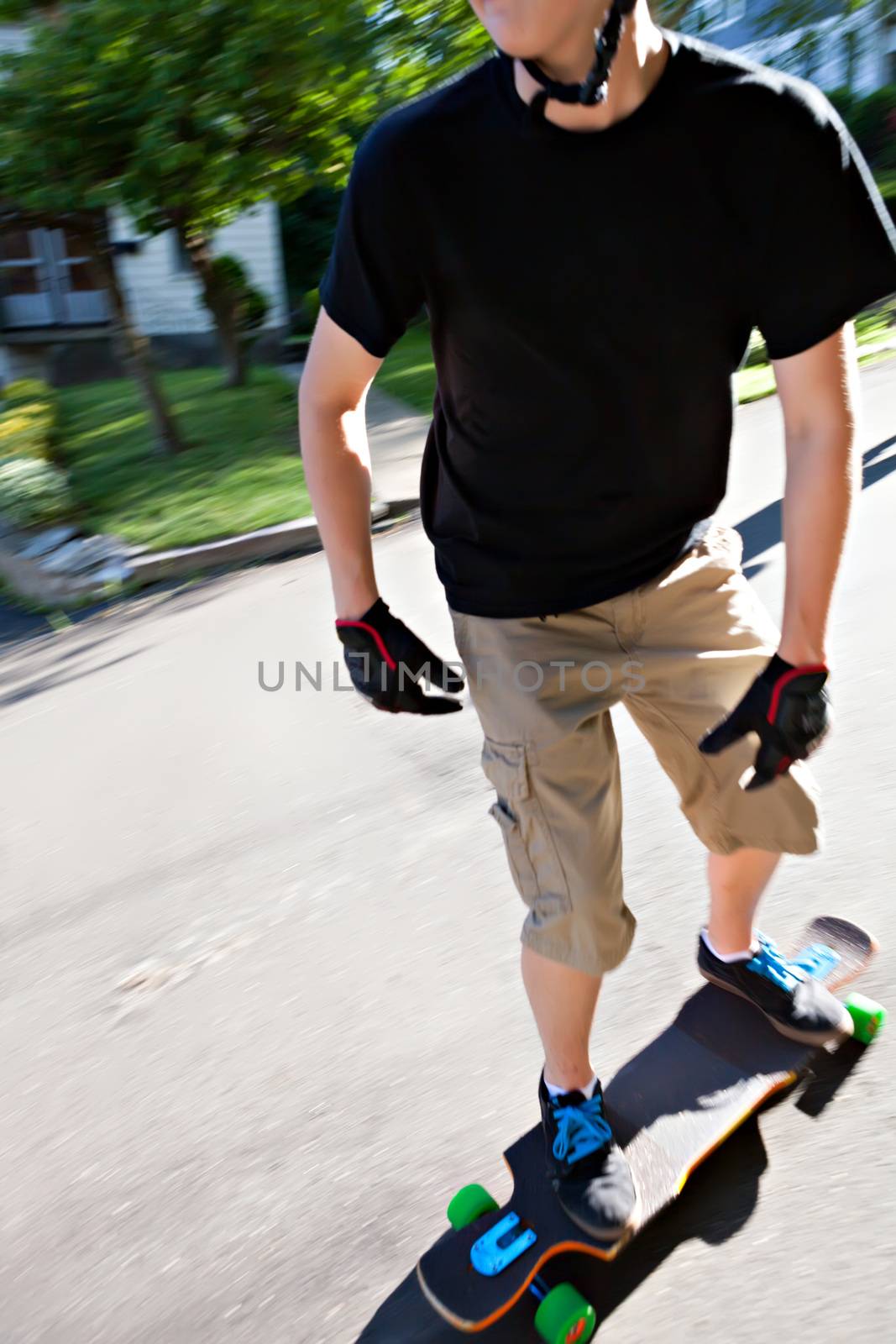 Action shot of a longboarder skating on an urban road. Slight motion blur.