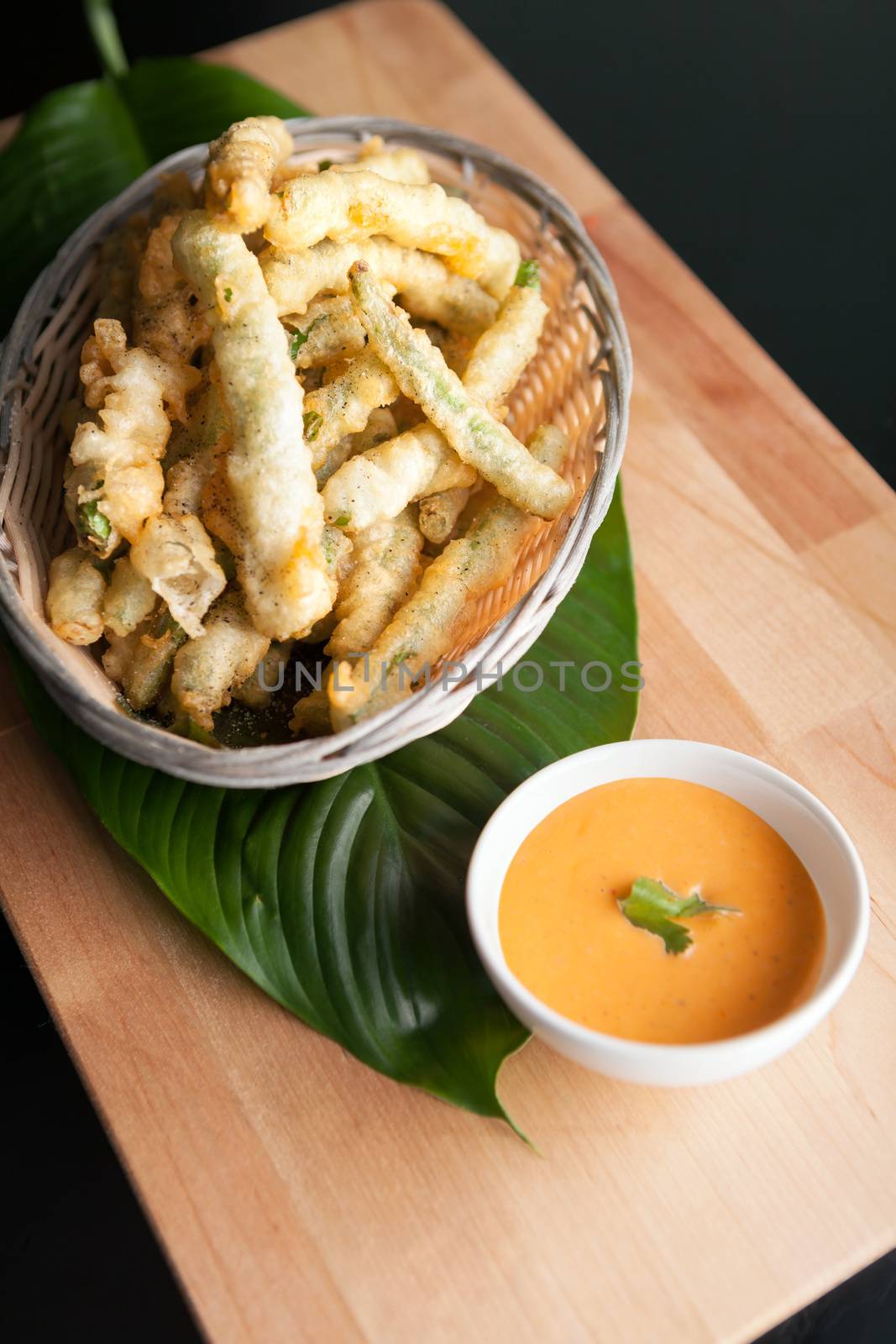 Thai style appetizer of fried tempura asparagus with dipping sauce. 