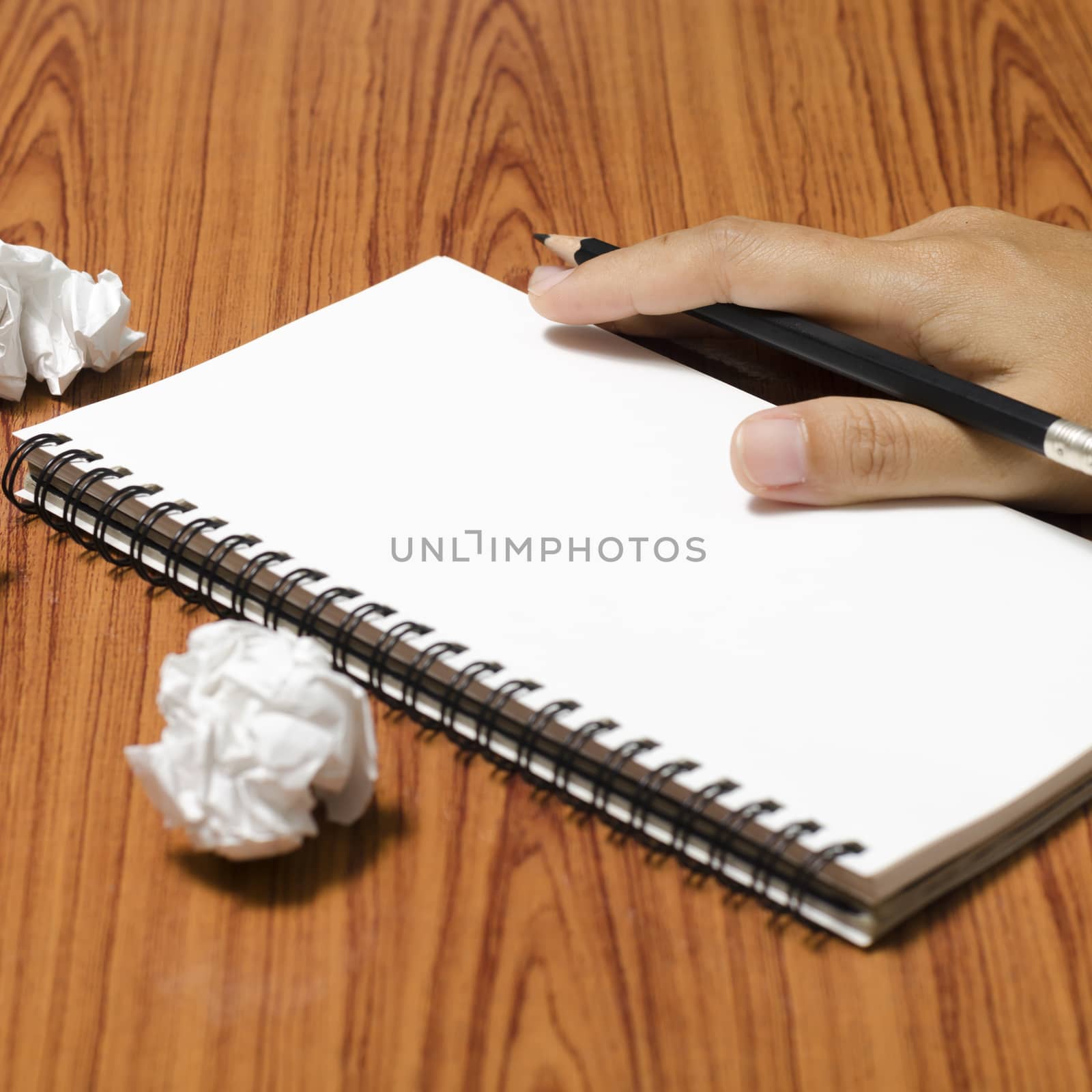 hand writing on notebook with crumpled paper on wood table background