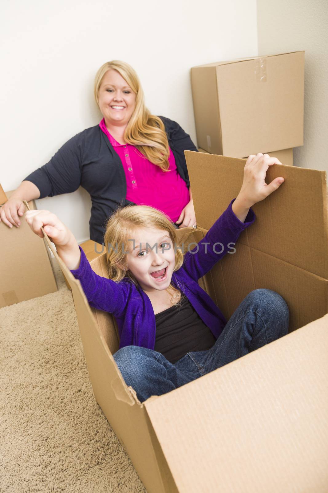 Young Family In Empty Room Playing With Moving Boxes by Feverpitched