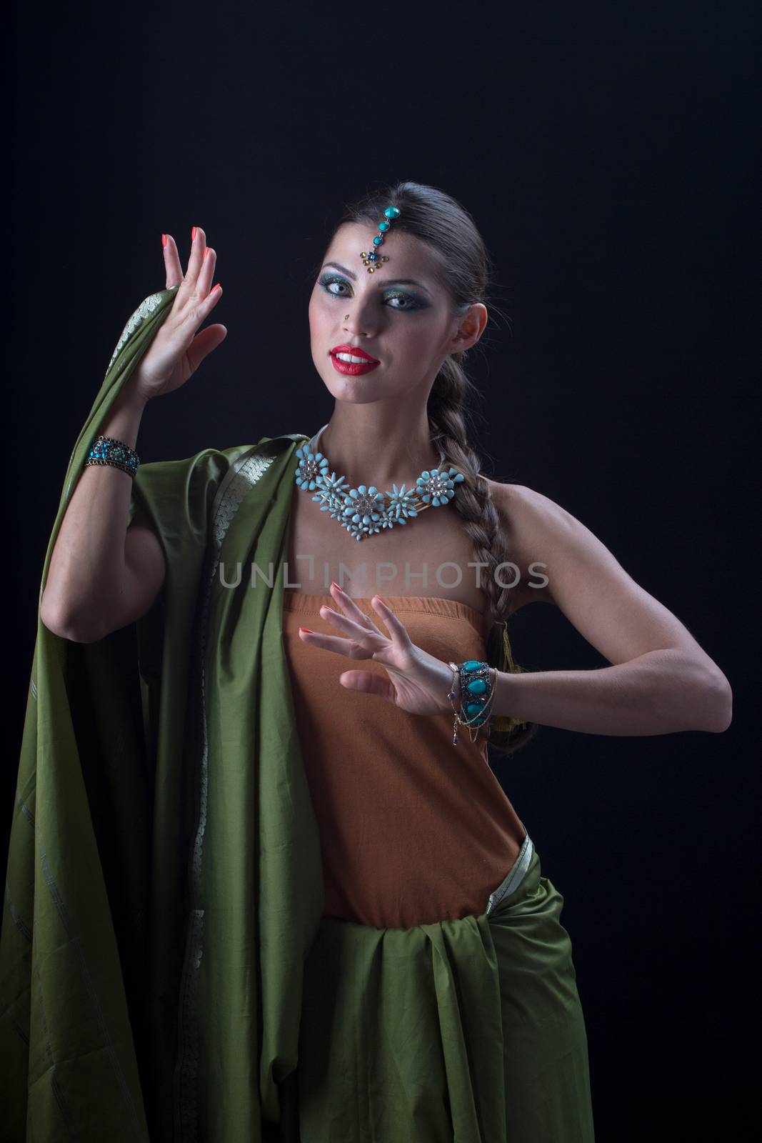 Beautiful Indian girl dancing in national dress on black background