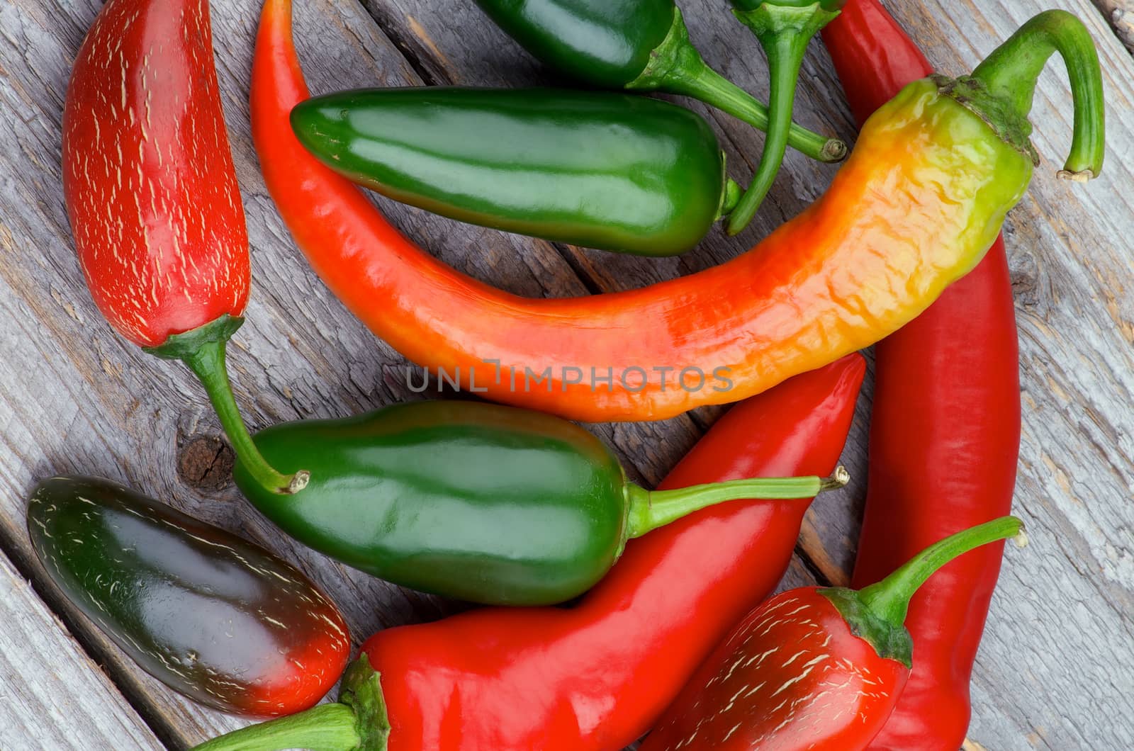 Heap of Red and Green Habanero and Jalapeño Chili Peppers isolated on Rustic Wooden background. Top View