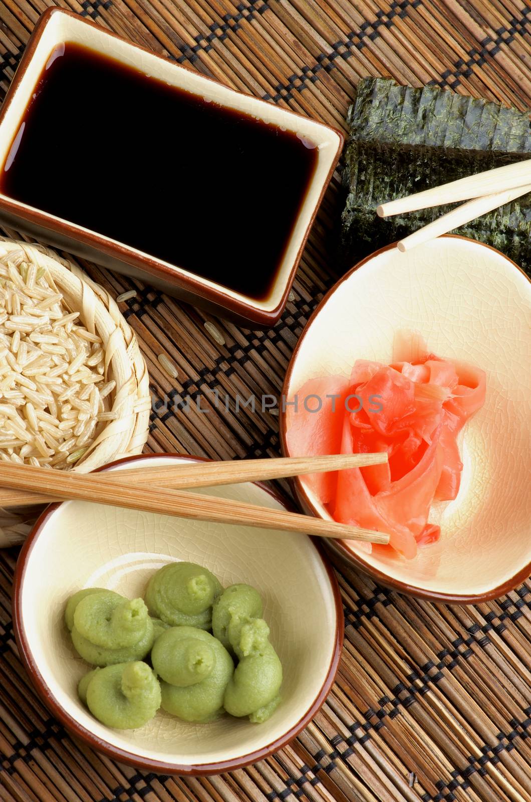 Ingredients to Preparing Sushi  with Nori, Ginger, Wasabi, Rice, Soy Sauce and Chopsticks on Bamboo Straw Mat