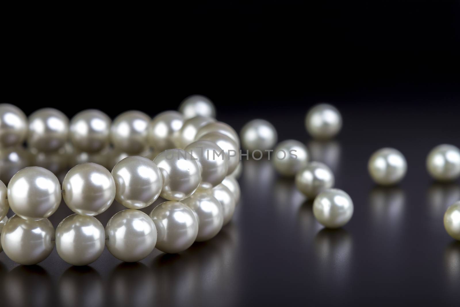 white pearls necklace on black background