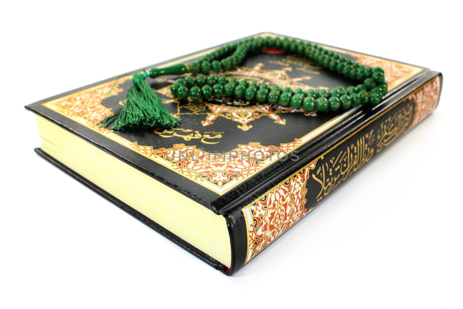 Quran with rosary in front of white background