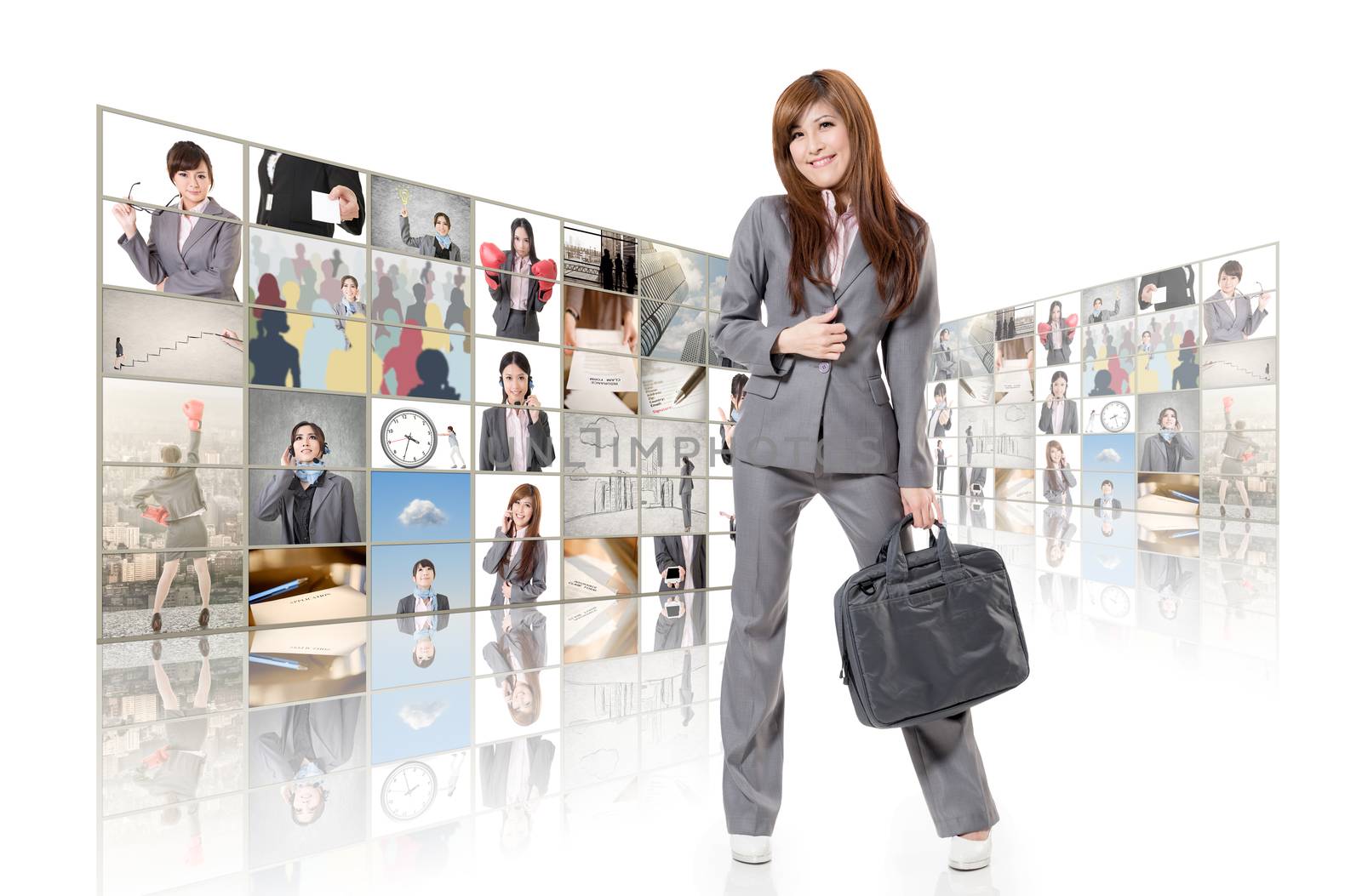 Cheerful Asian business woman standing in front of TV screen wall.