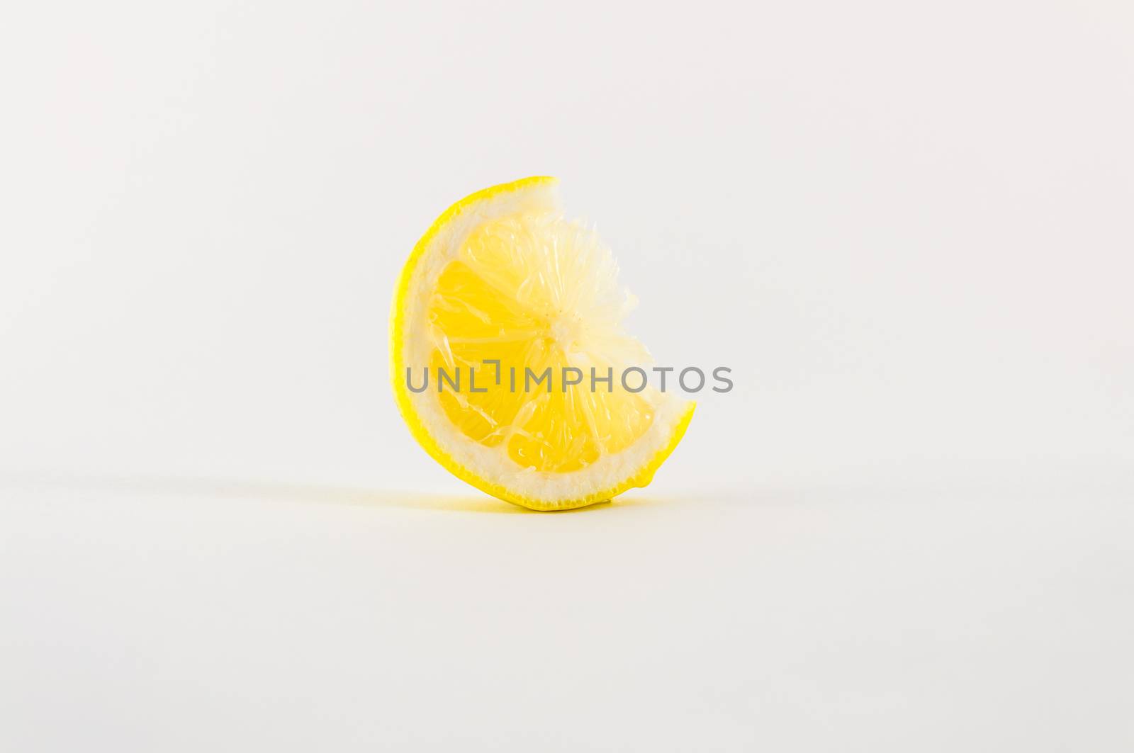Slice of fresh lemon yellow on white background