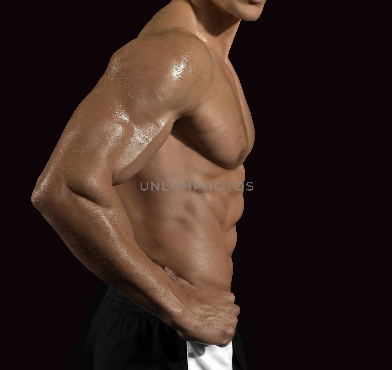 Muscular young man torso profile. Isolated with path on black.