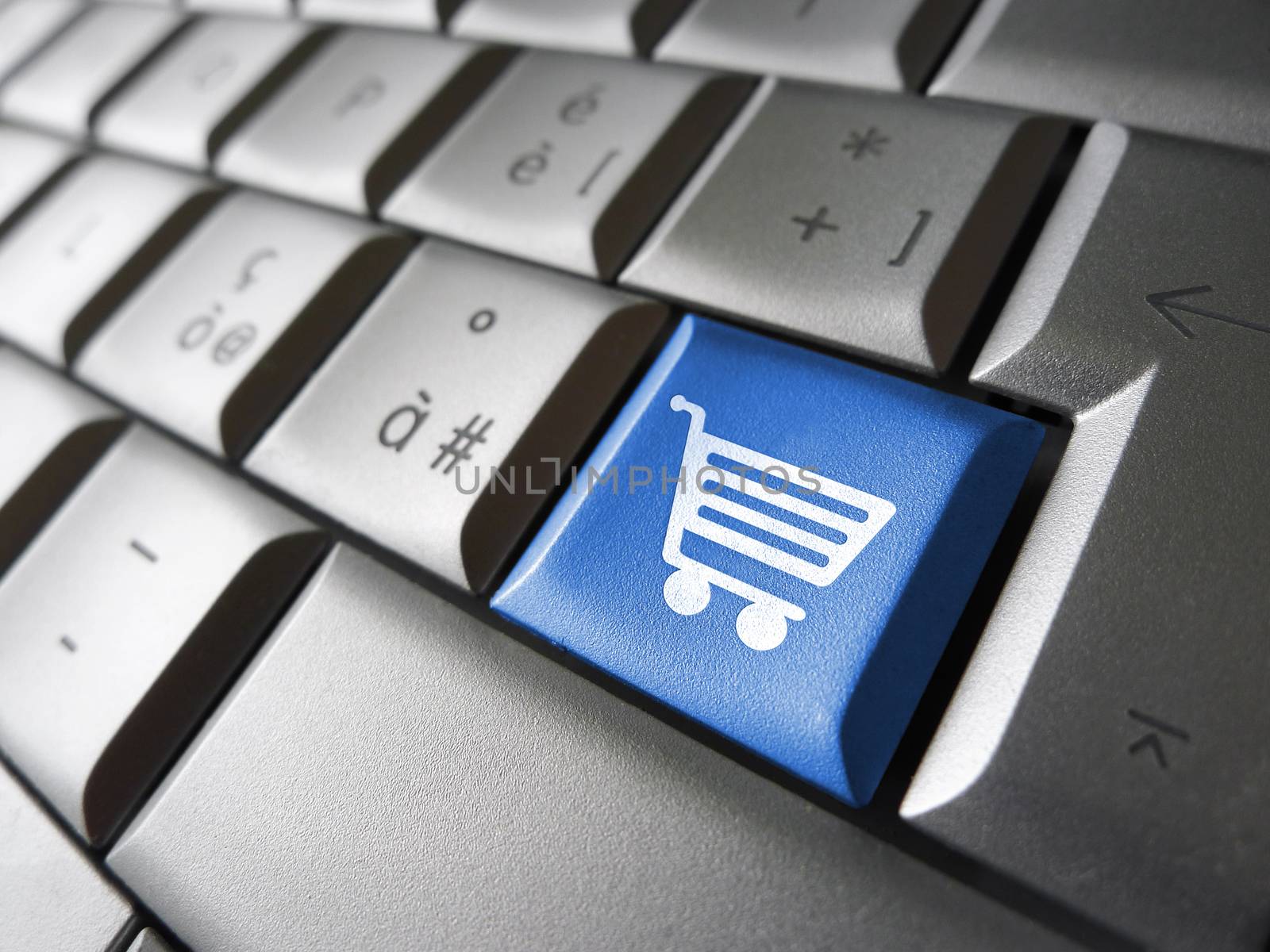 Online e-shopping concept with basket icon and symbol on a blue laptop computer key for Internet website and on line business.