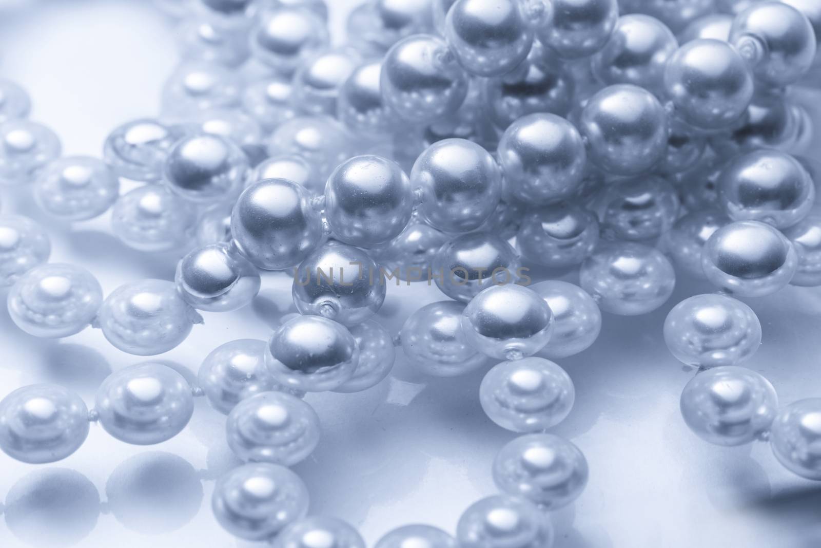 Shining string of white pearl in water by Garsya