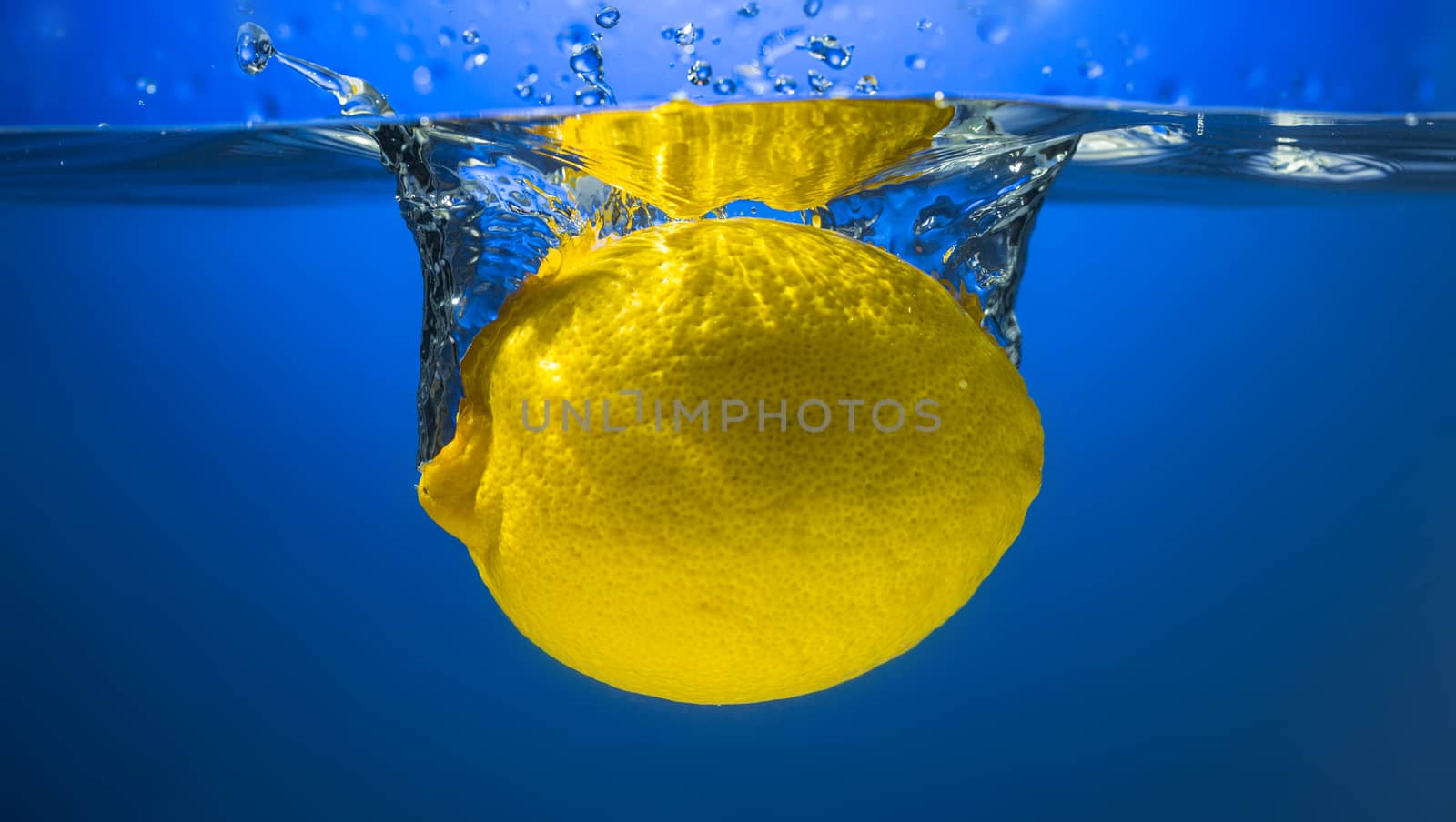 Yellow lemon in water splash by Garsya