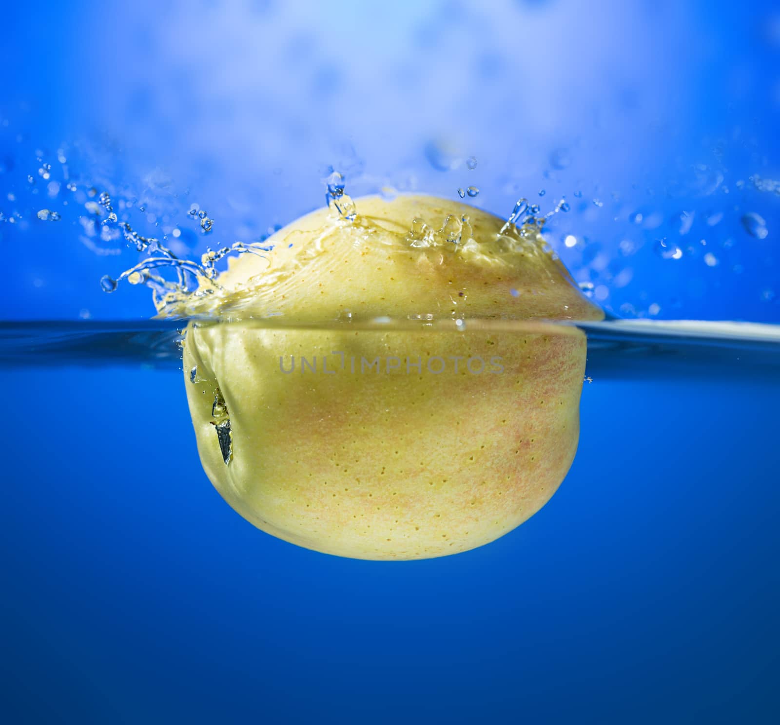 Yellow apple in water splash