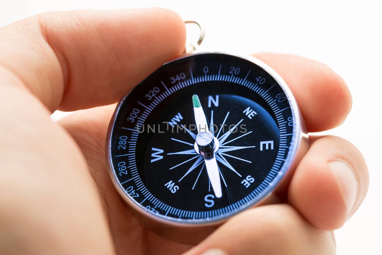 Hand holding silver black compass by Garsya