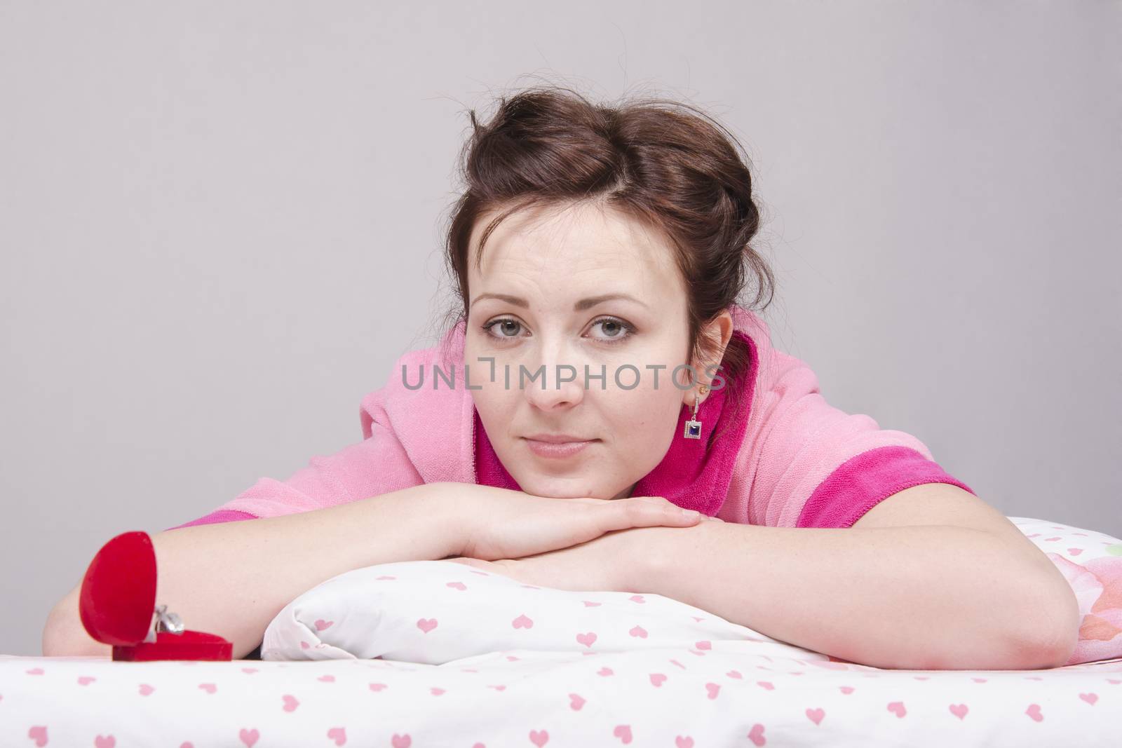 The girl gave a gift in the morning in bed, gave her a ring in the case.