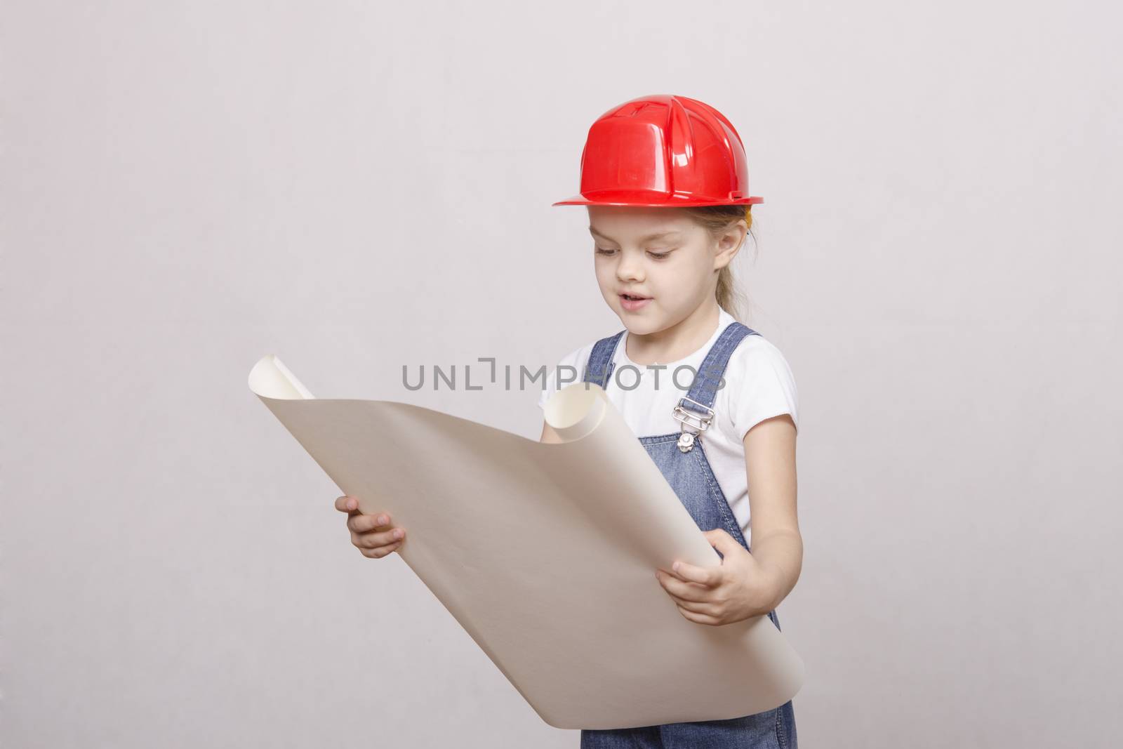 Girl playing Builder launched the drawing up and looks into the drawing