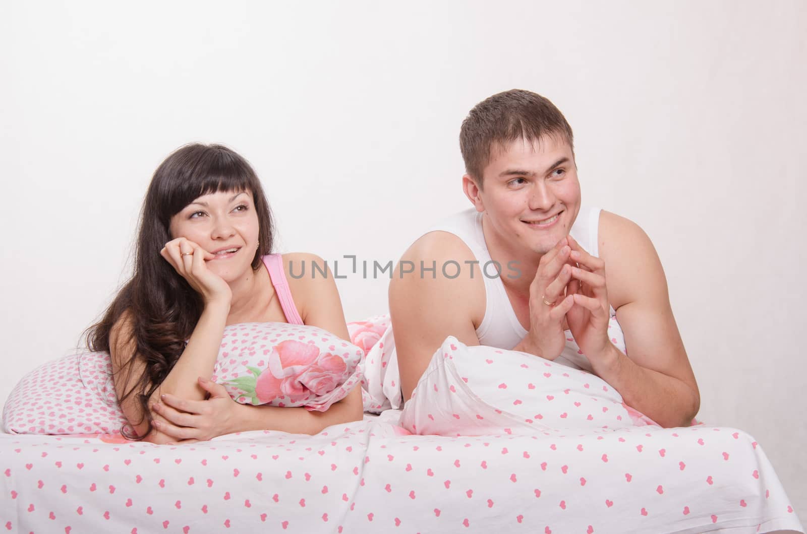Young beautiful couple are thinking about the problems lying in bed