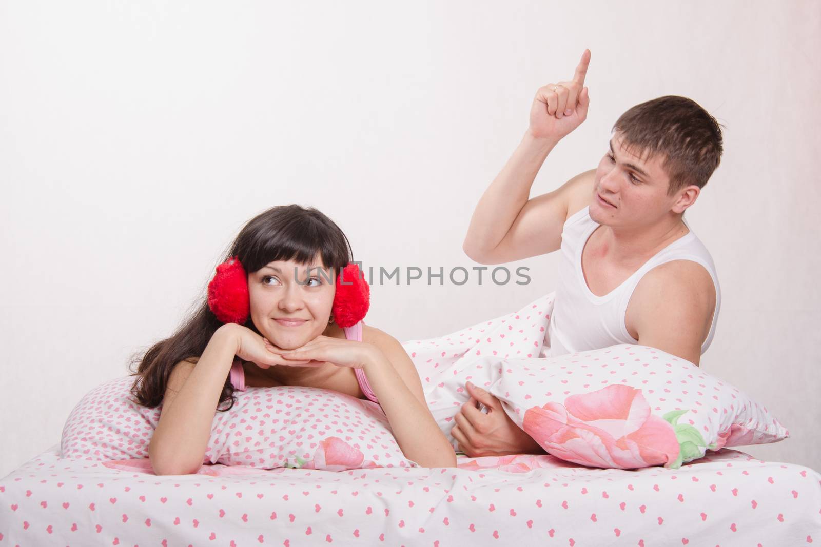 Young family couple quarrels in a bed
