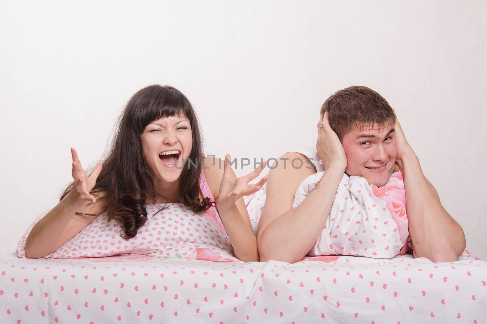 Young family couple quarrels in a bed