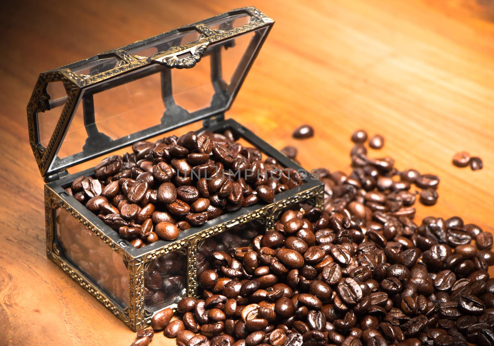 Coffee beans in coffer on teak wooden background