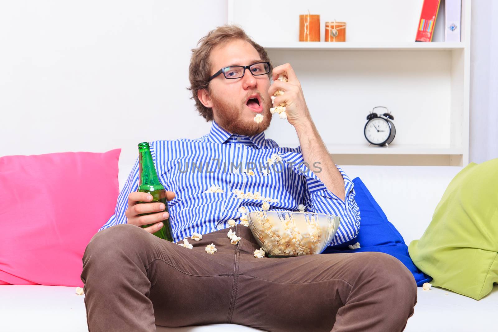 Man eating popcorn on the sofa - studio shoot 
