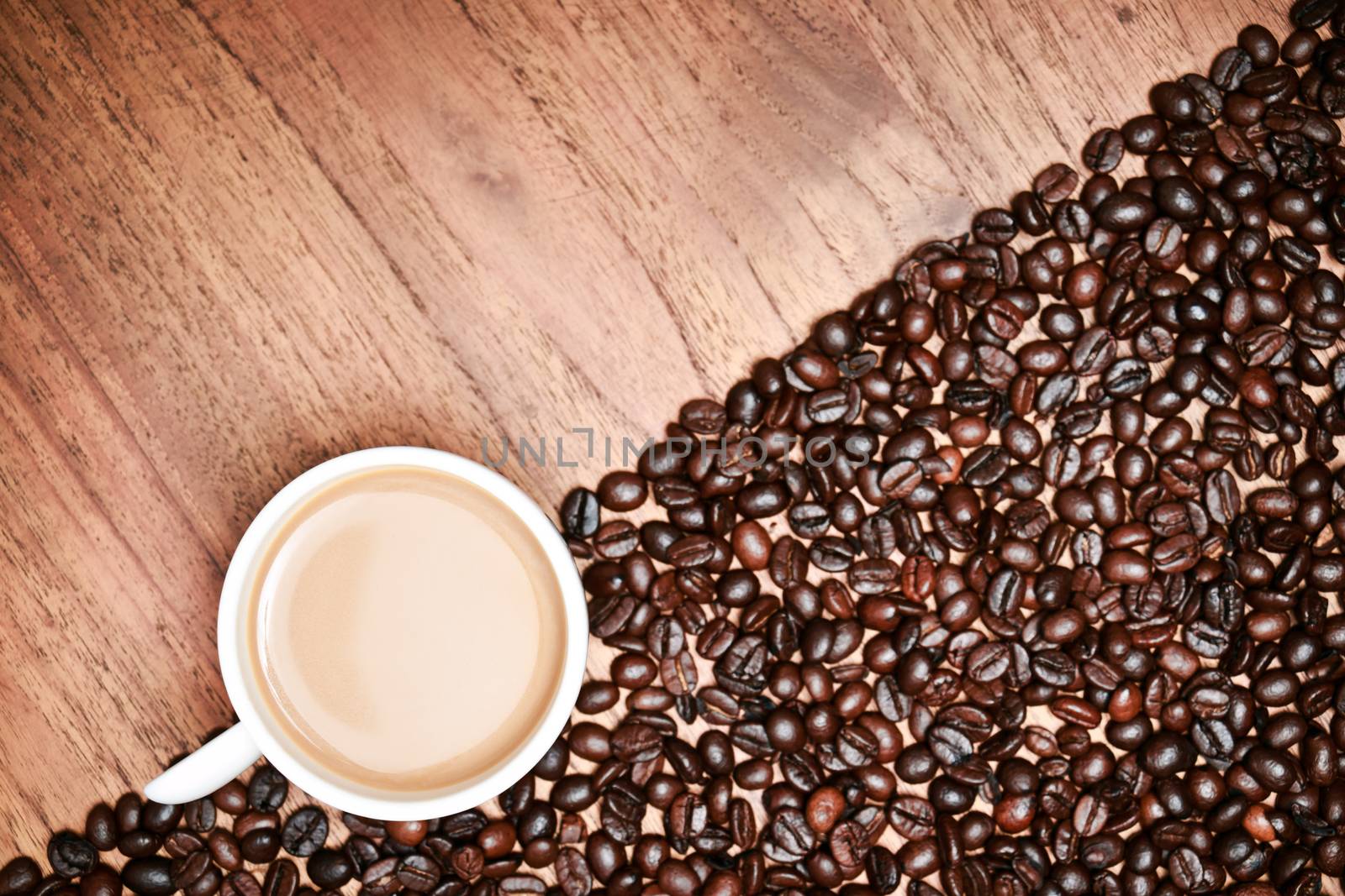 Coffee cup and coffee beans on teak wooden table, vintage