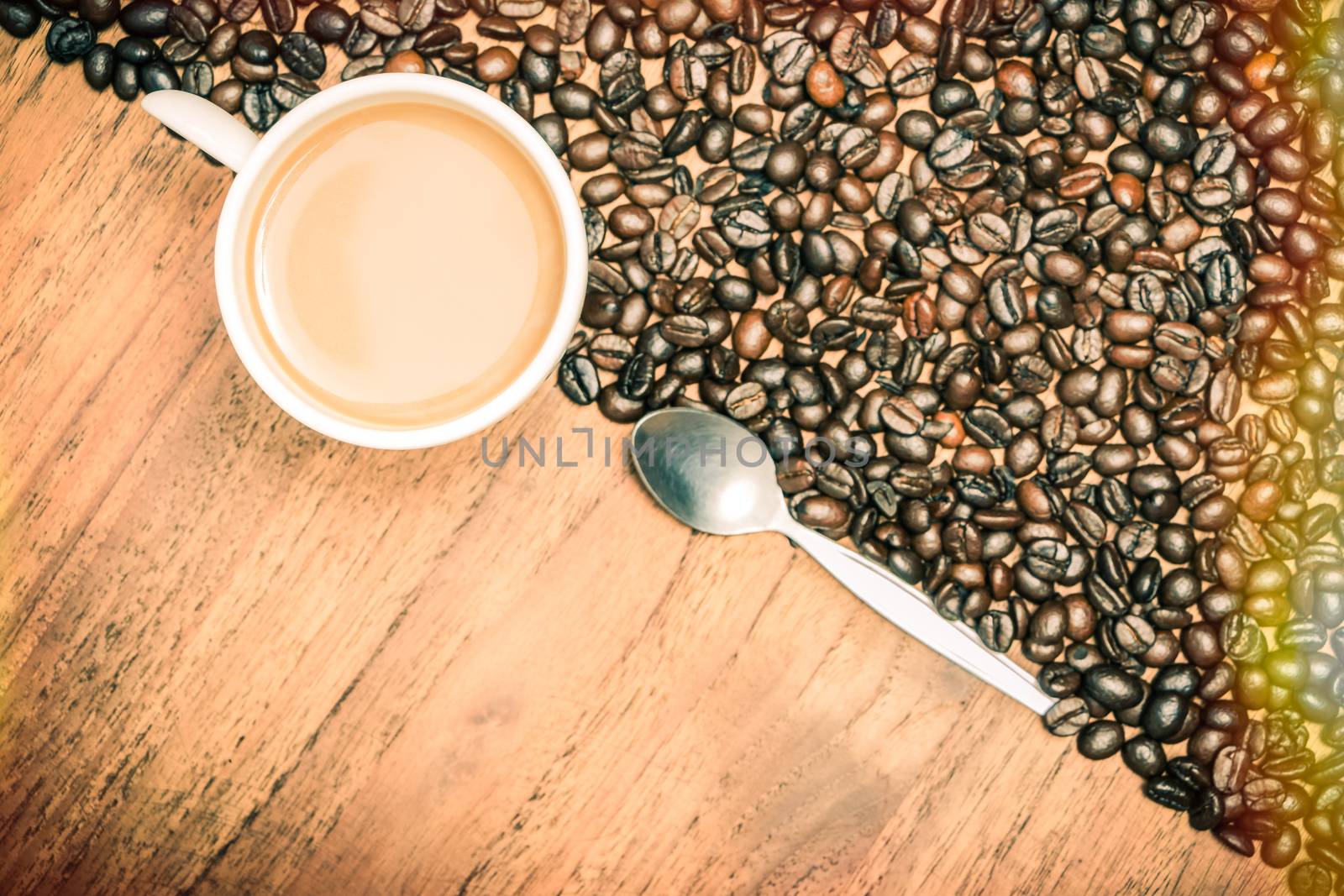 Coffee cup and coffee beans on teak wooden table, vintage