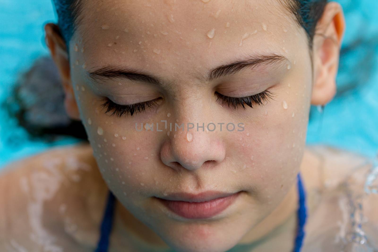 girl with a wet face in a pool