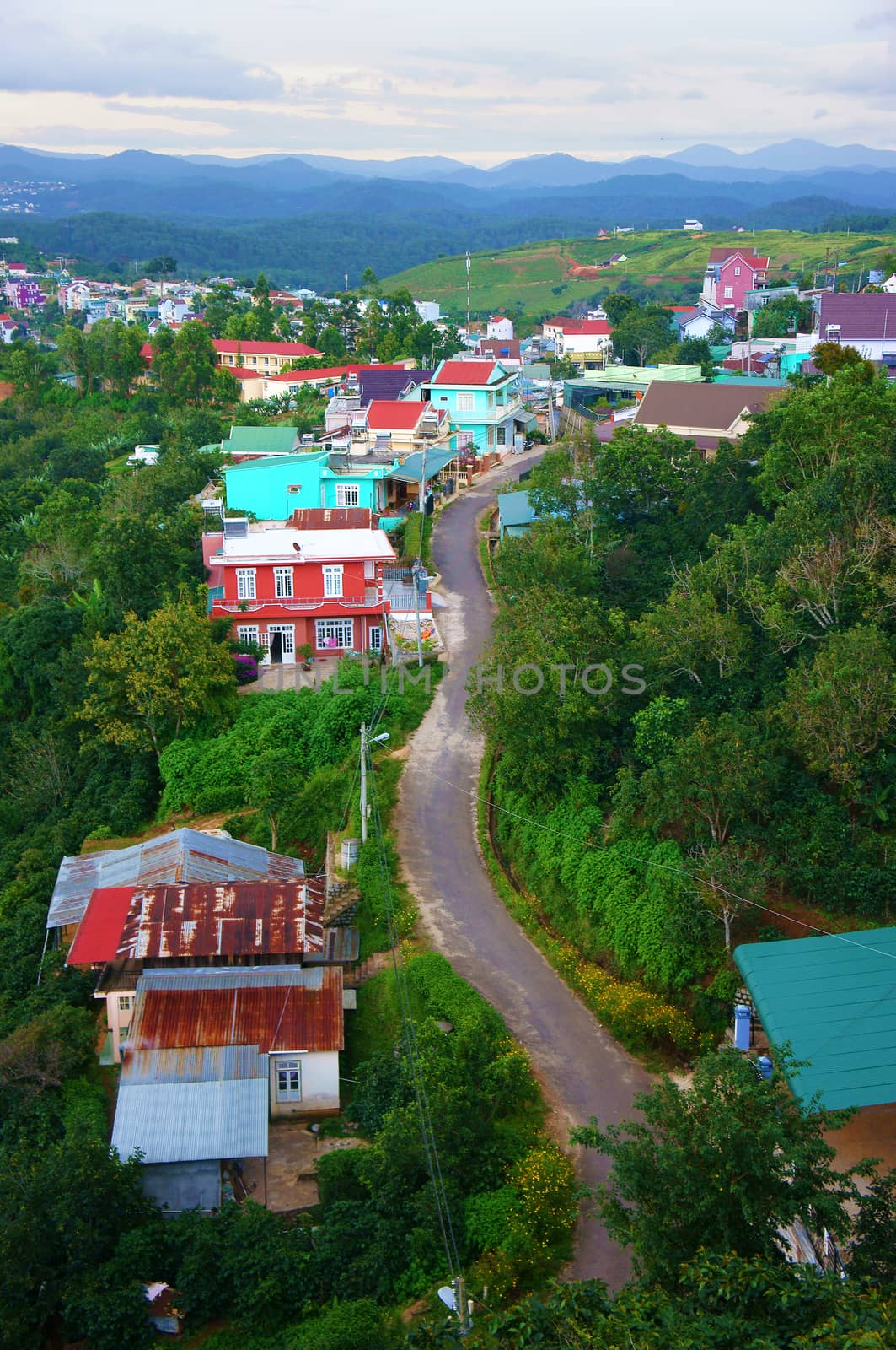 DA LAT, VIET NAM- SEPT 2: Scene of Dalat suburbs at evening, group of colorful house, country road, chain of mountain far away, countryside cover with green, fresh air, Vietnam, Sept 2, 2014