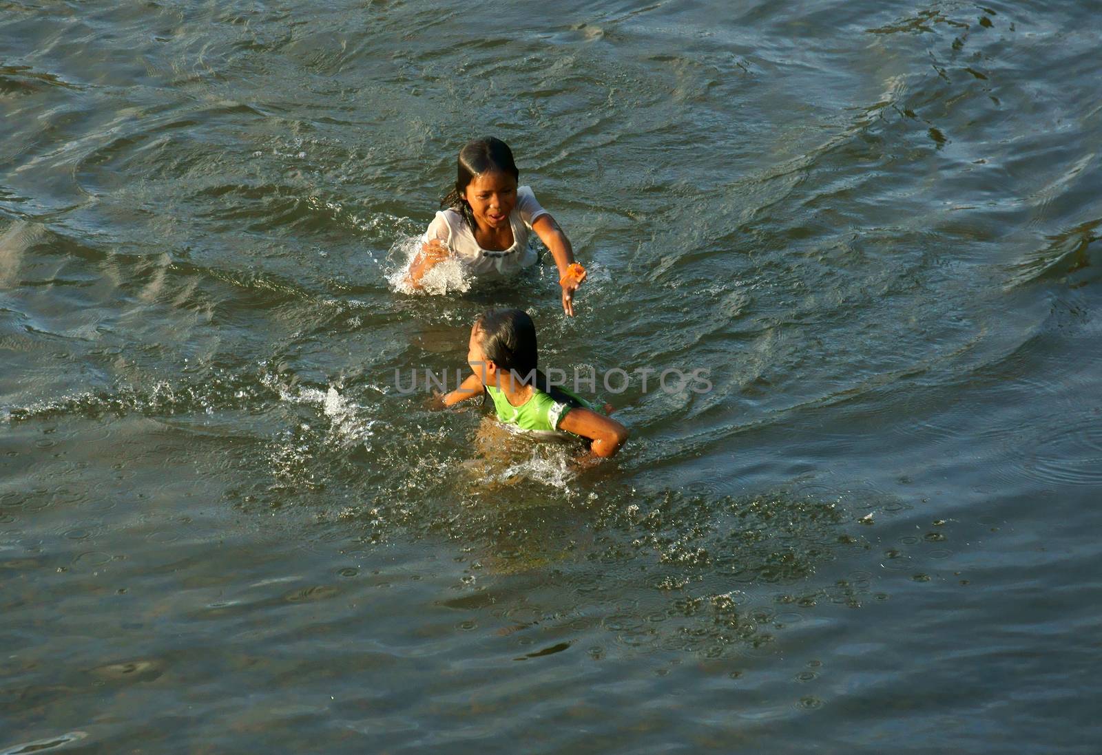 KHANH HOA, VIET NAM- FEB 5: Lifestyle of Vietnamese country children, group of Asian girl bath on river, they swim, splash water, laugh with friend in summer, Vietnam, Feb 5, 2013