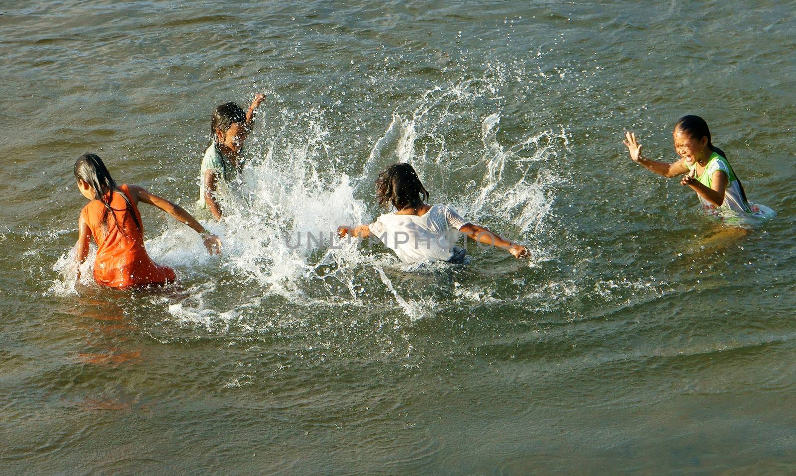 KHANH HOA, VIET NAM- FEB 5: Lifestyle of Vietnamese country children, group of Asian girl bath on river, they swim, splash water, laugh with friend in summer, Vietnam, Feb 5, 2013