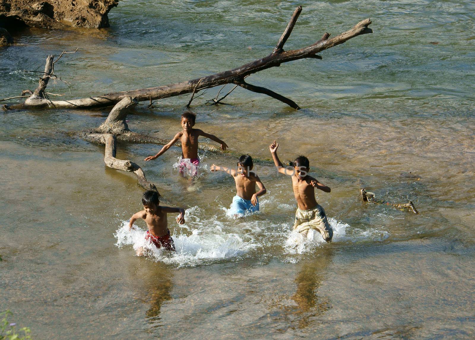 KHANH HOA, VIET NAM- FEB 5: Lifestyle of Vietnamese country children, group of Asian boy bath on river, they swim, splash water, run with friend in summer, Vietnam, Feb 5, 2013