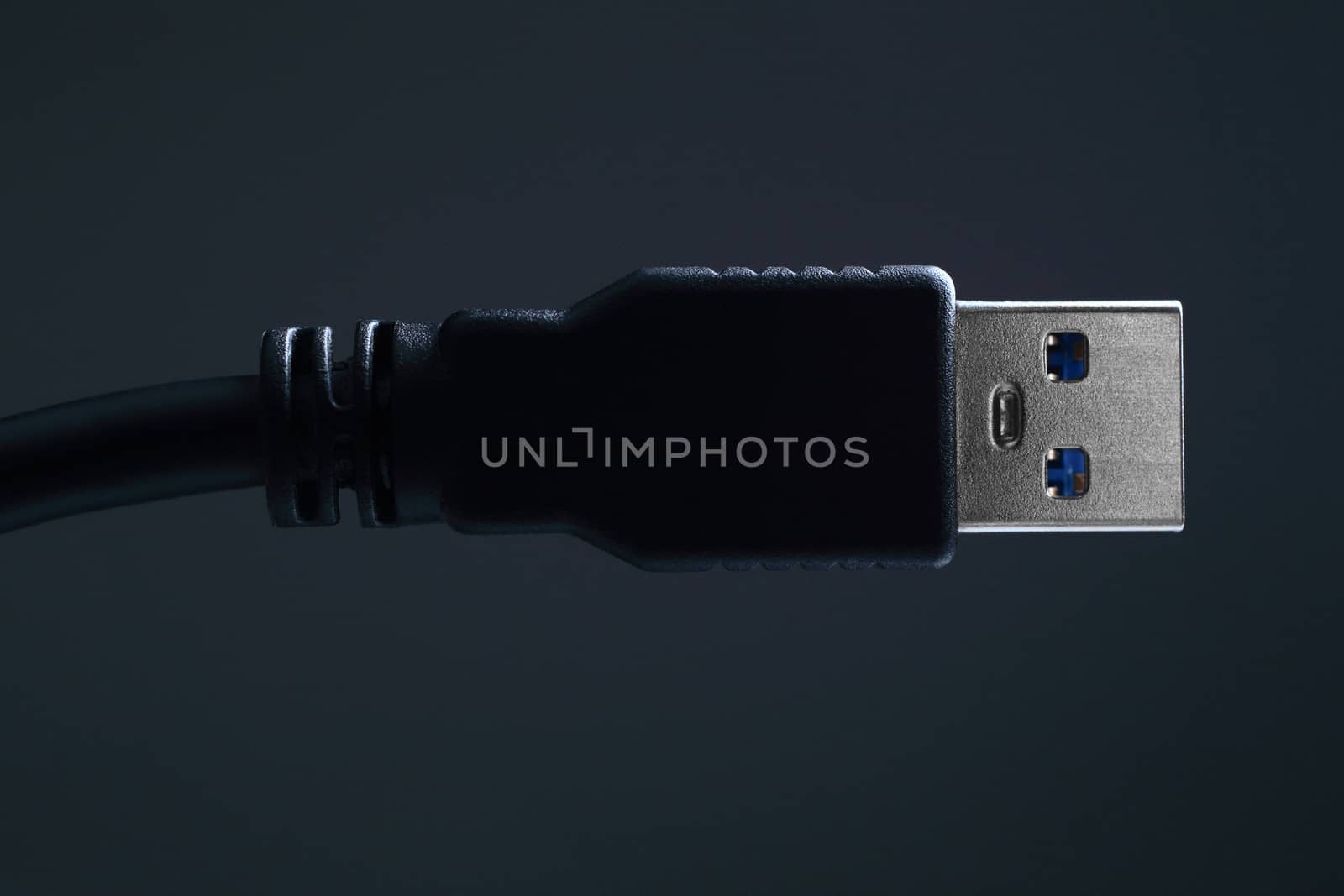 Close-up black USB cable on dark background.