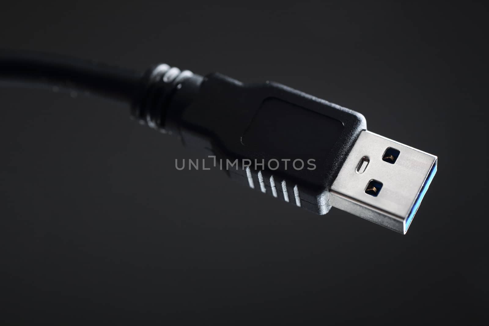 Close-up black USB cable on gray background.