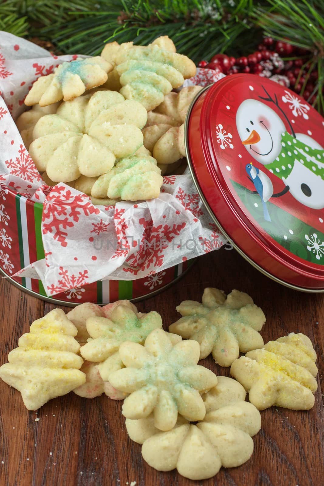 Christmas cookies in a decrative metal tin, sitting on a table.
