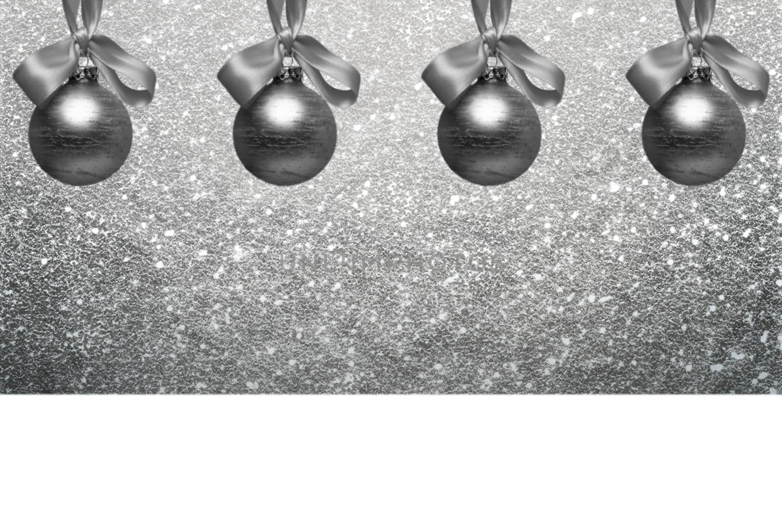 silver christmas bulbs in front of silver glitter background