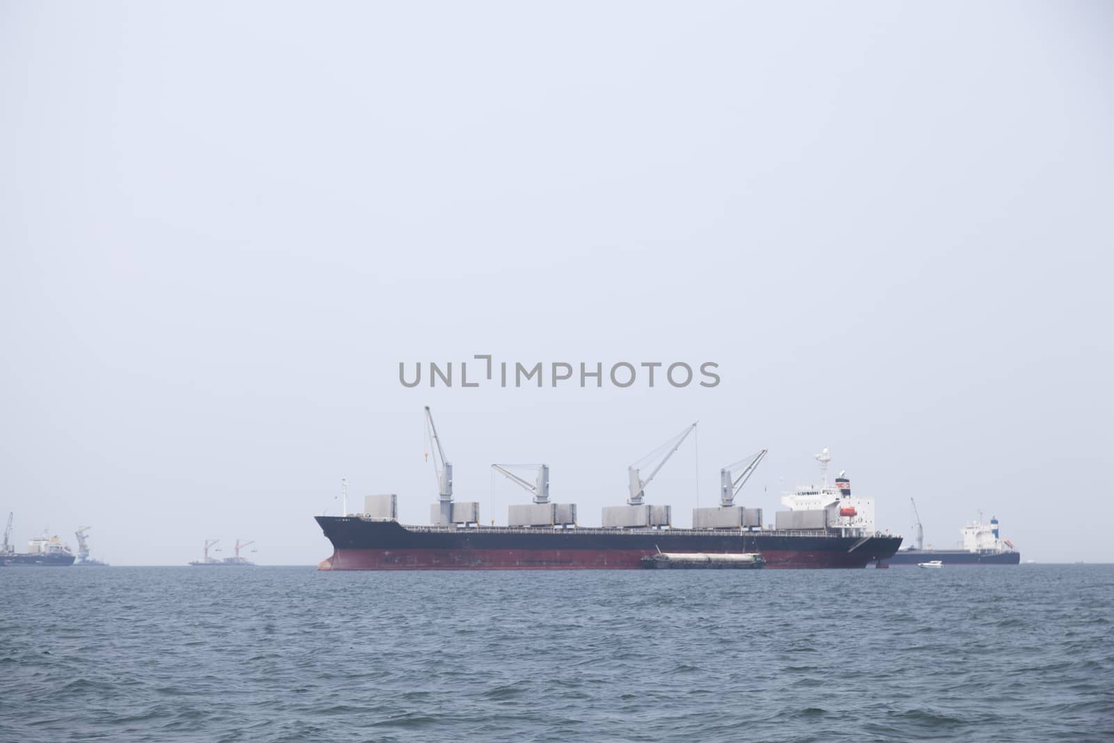 Large cargo ship Boats moored in the sea to make sense compared to the coast.