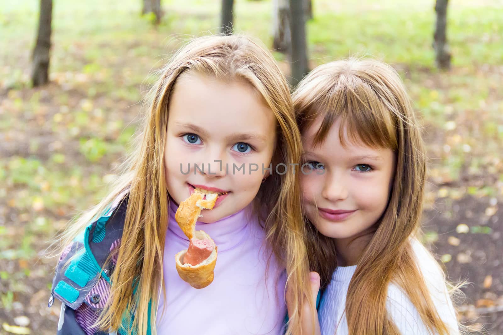 Photo of two eating girls in summer