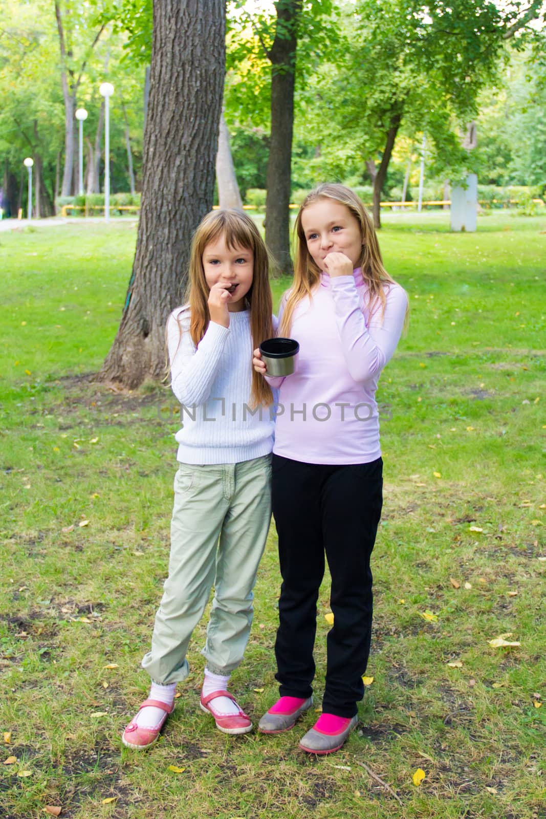 Photo of two eating girls in summer