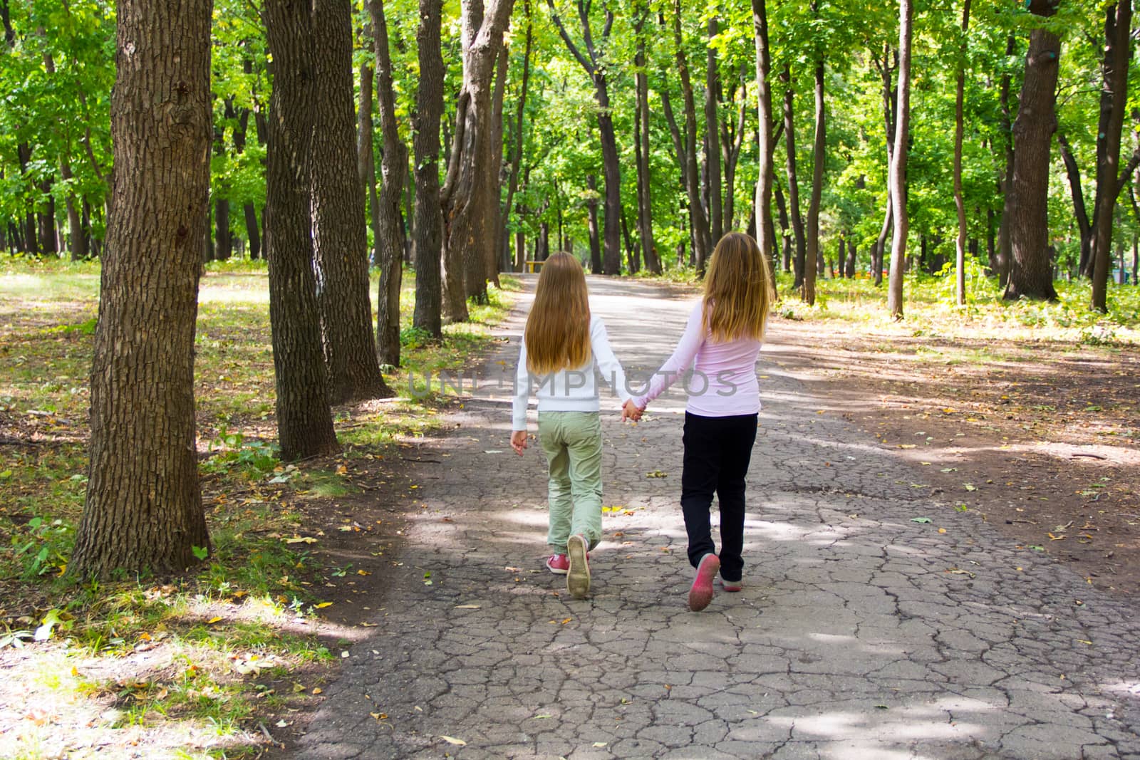 Photo of cute two girls walking in park