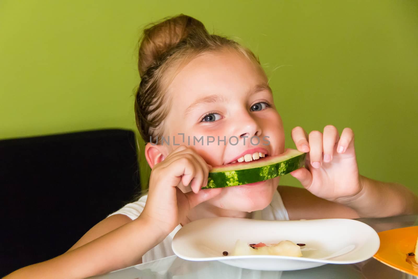 Photo of the cute girl eating watermelon