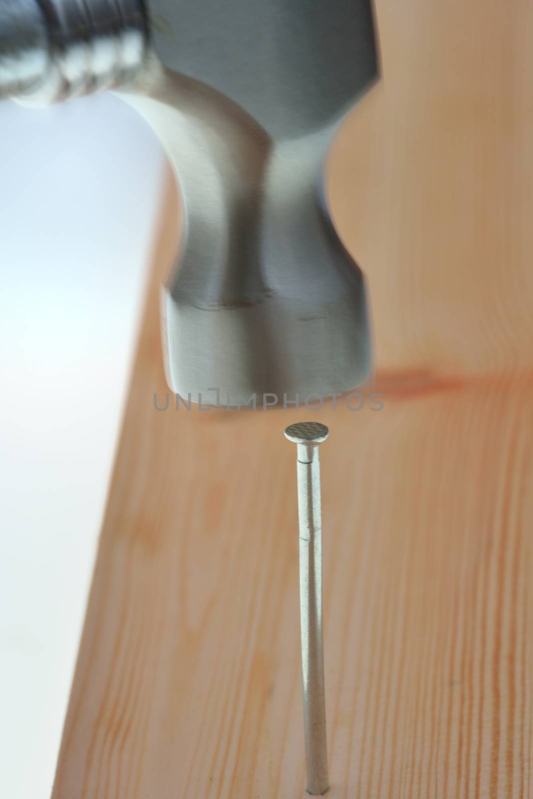 hammering nail into plank