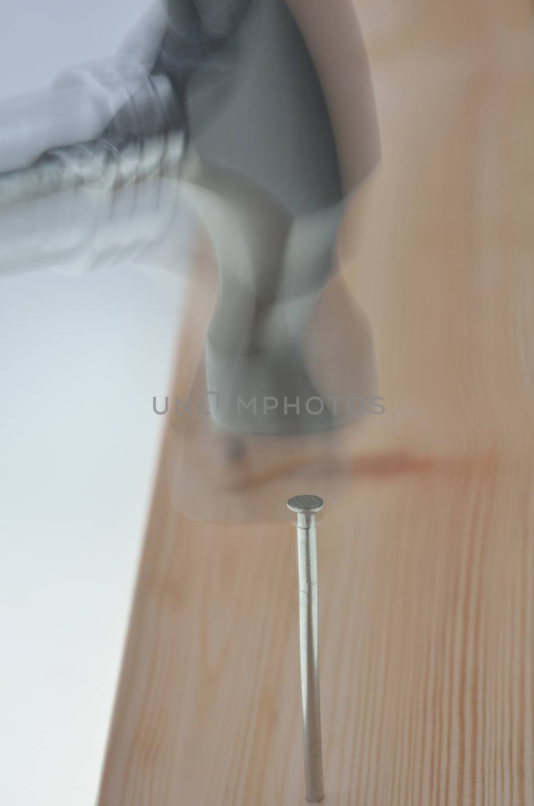blurred image of nail being hammered into plank