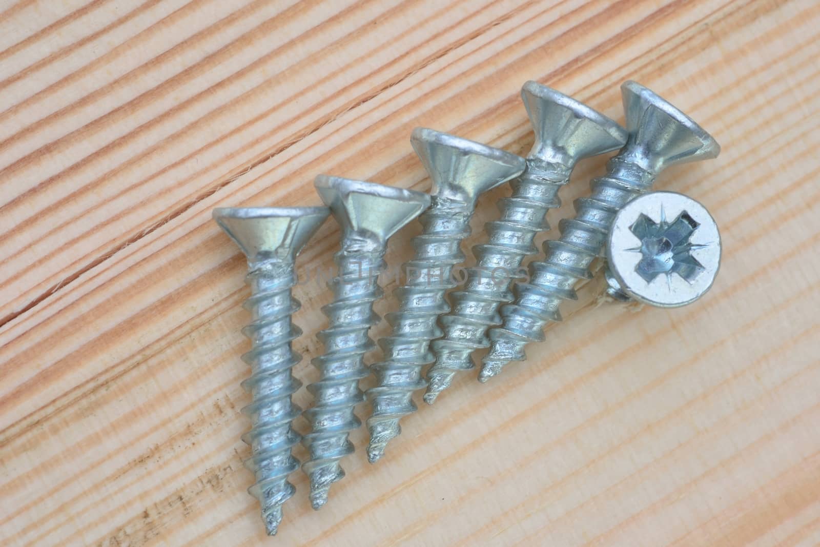 group of screws on wood background by pauws99