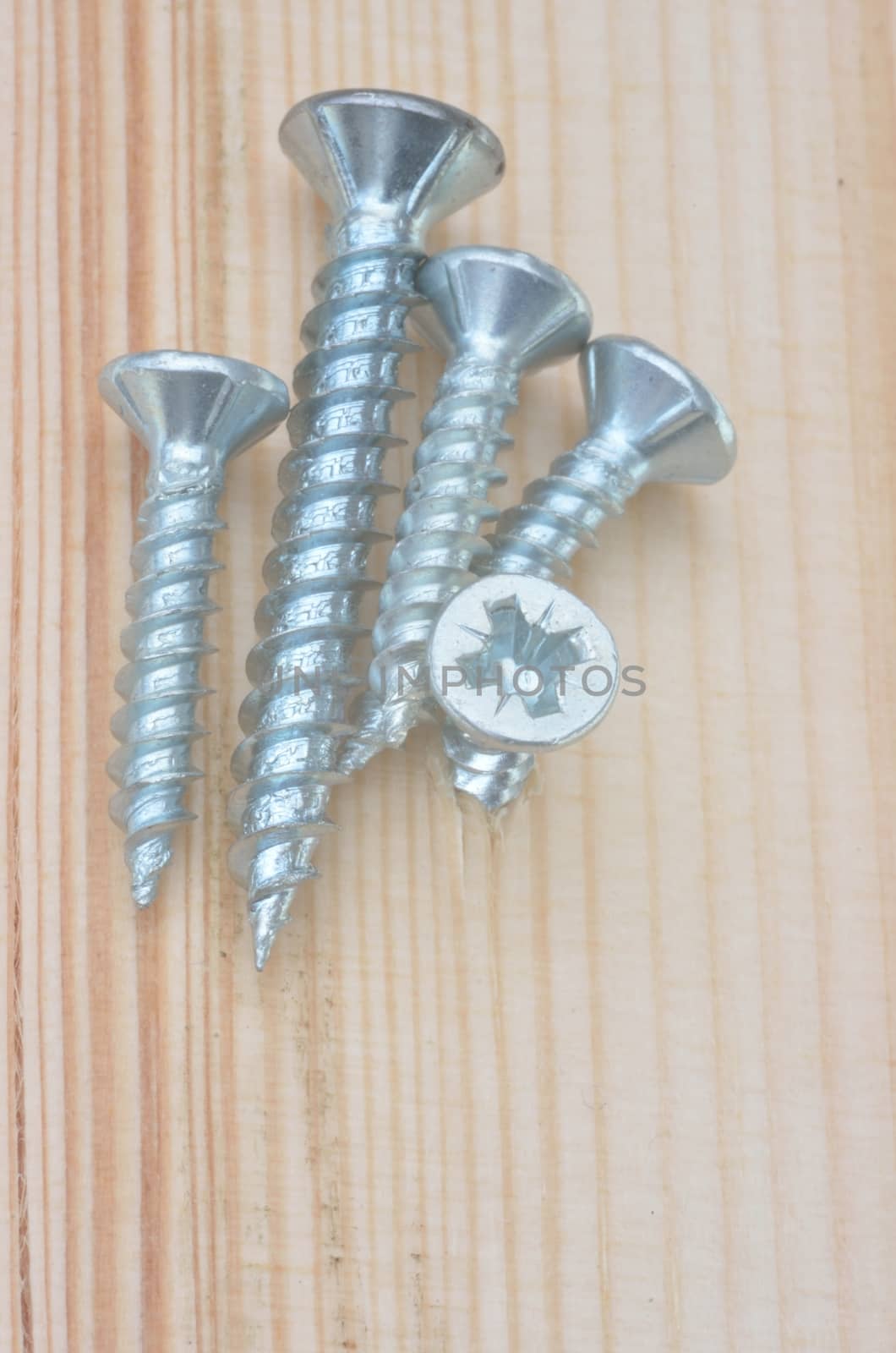 Group of screws on wooden background