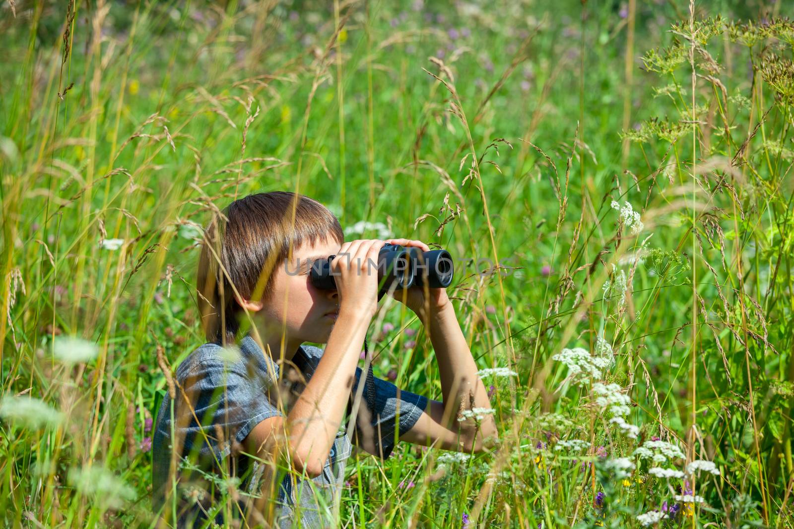Child looking through binoculars by naumoid