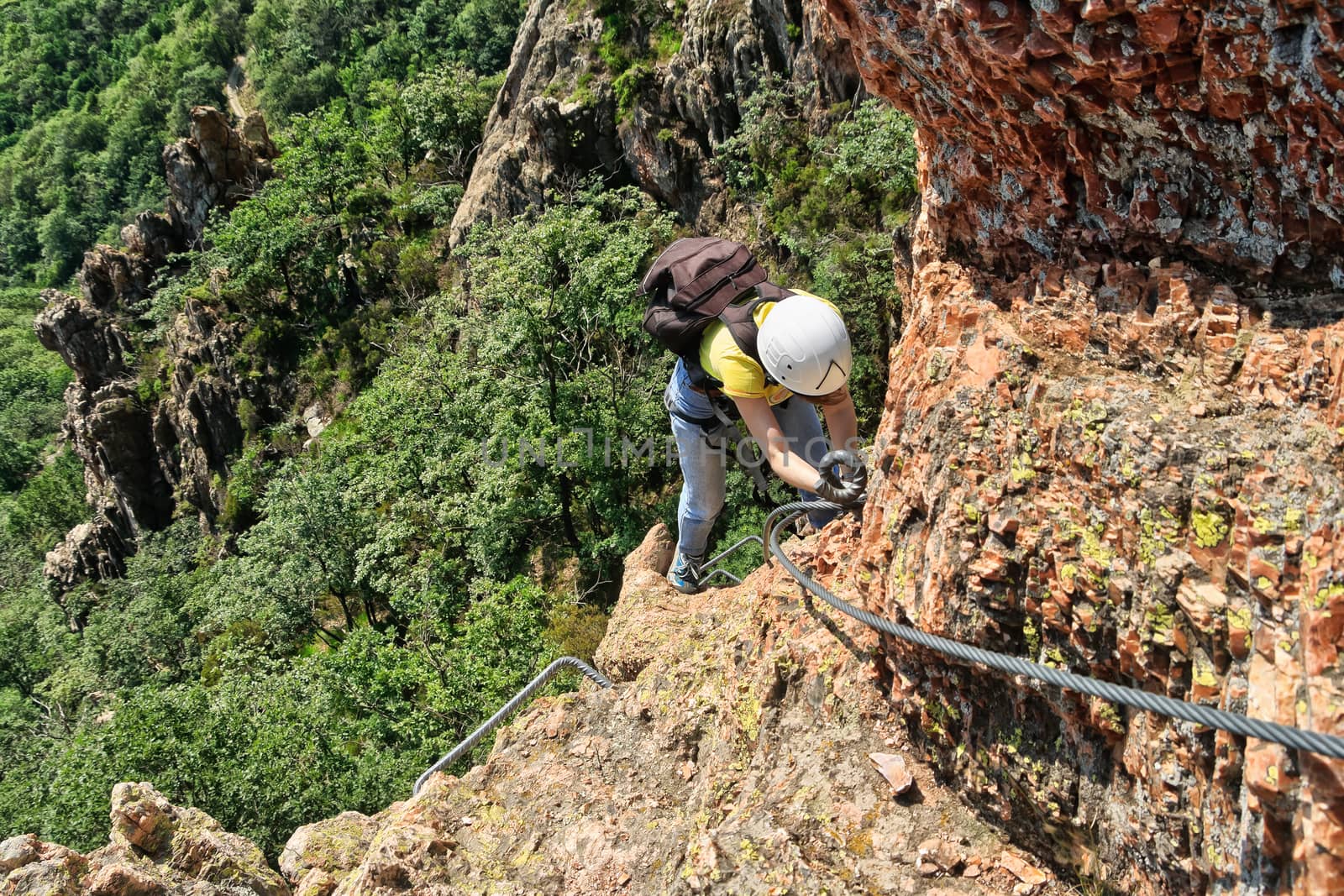 climber on a exposed ridge in Via Ferrata degli Artisti, Liguria, Italy