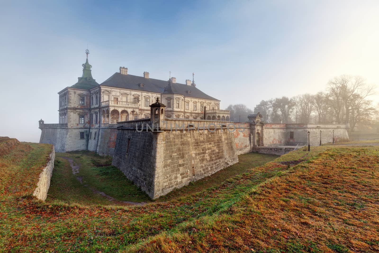 Ancient castle in the morning fog. Autumn season